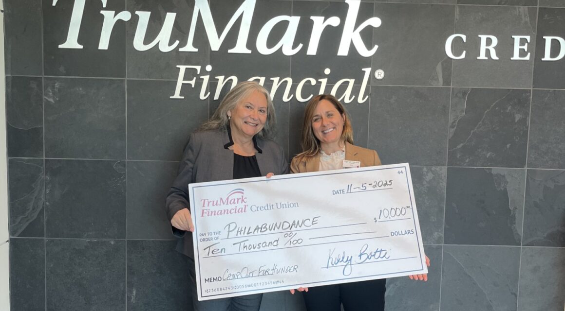Women holding up giant donation check