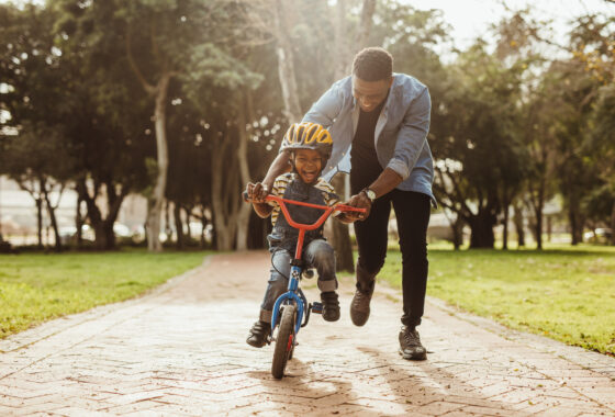 Dad helping his son ride a bike